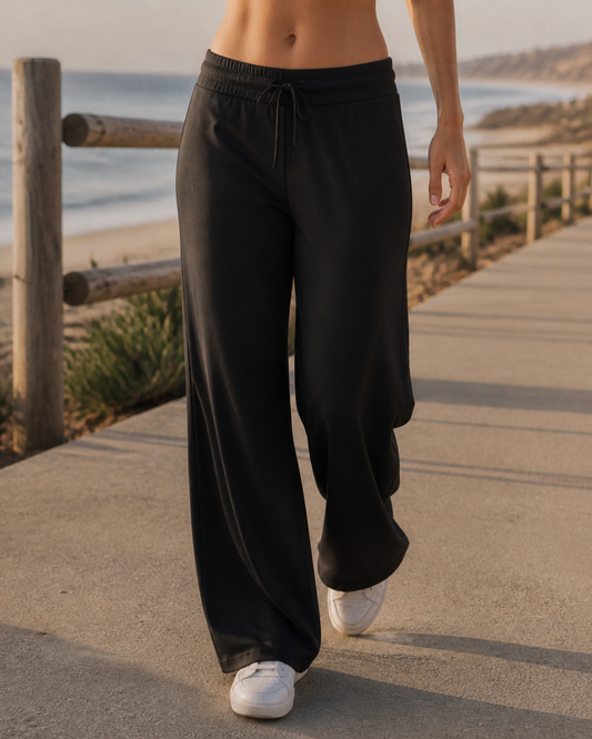 Black Athflow Pants worn on a coastal boardwalk