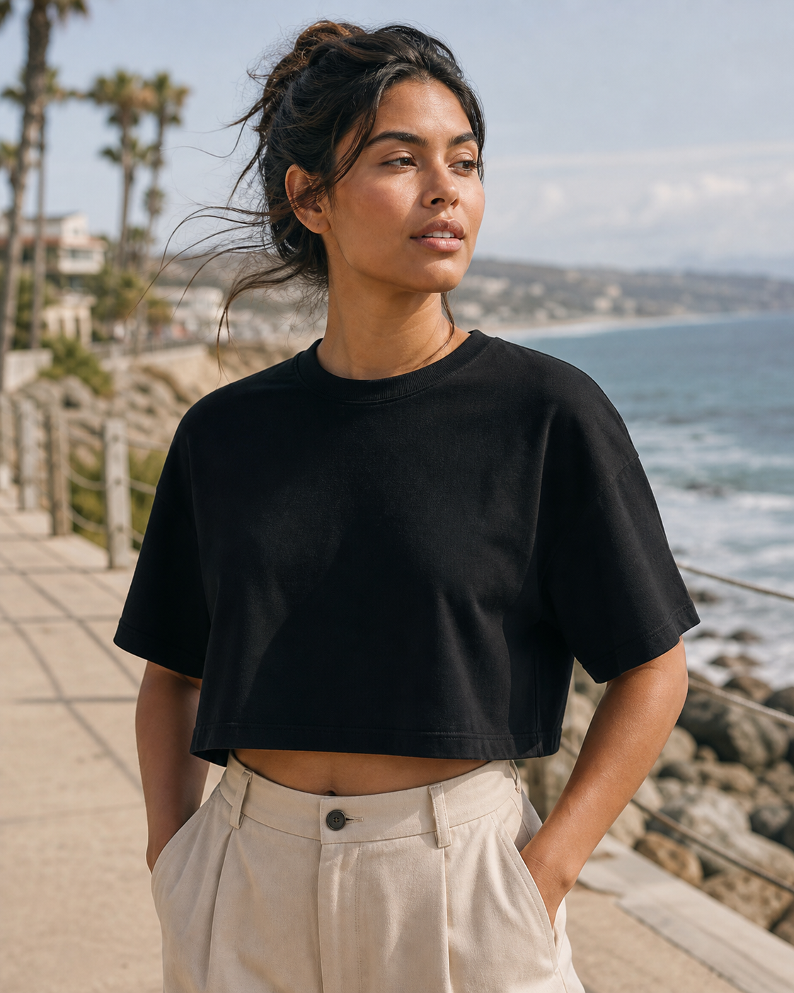 Black Boxy Crop Top worn on a coastal boardwalk