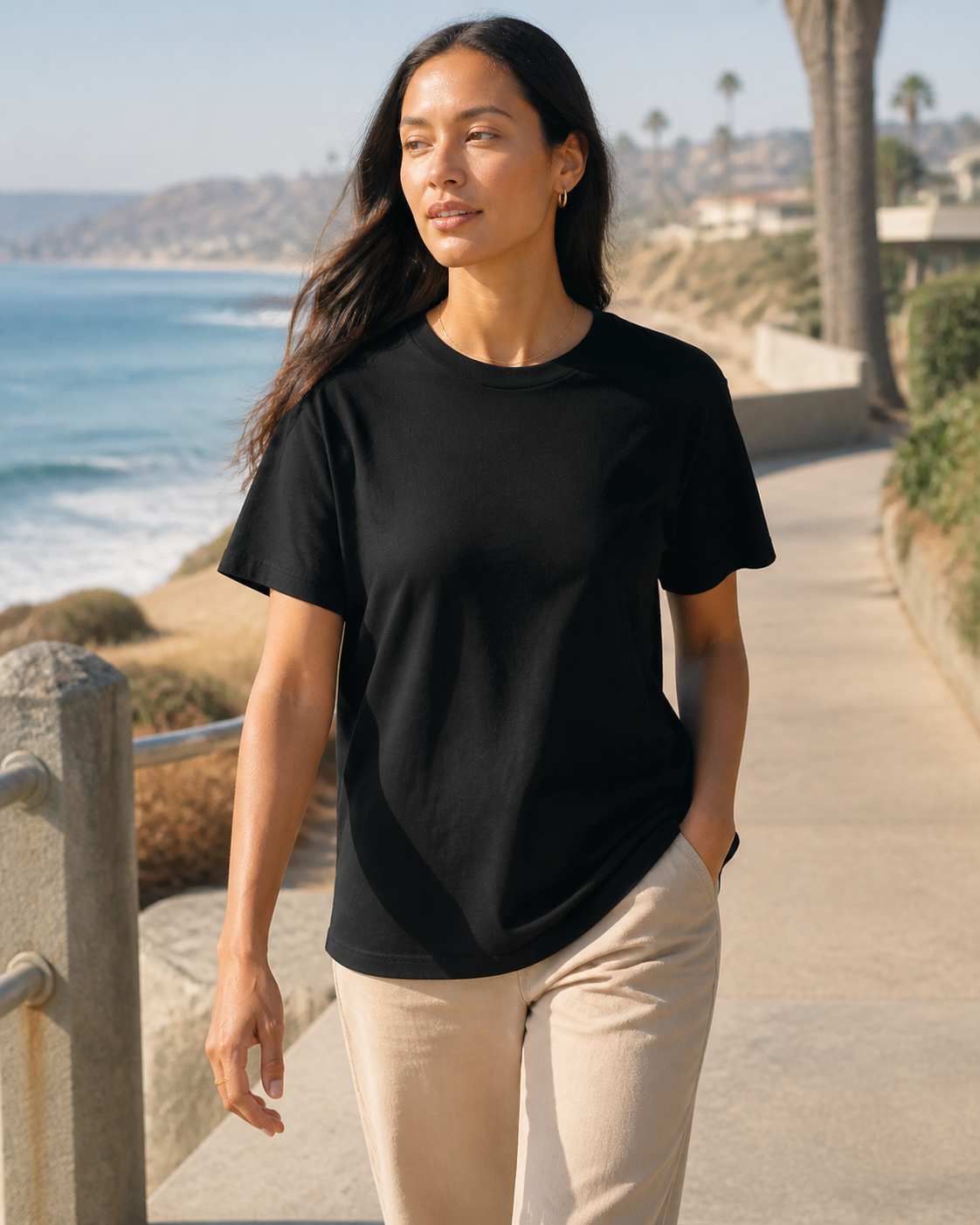 Model wearing KeAloha Black Boyfriend-Fit Tee on a coastal promenade