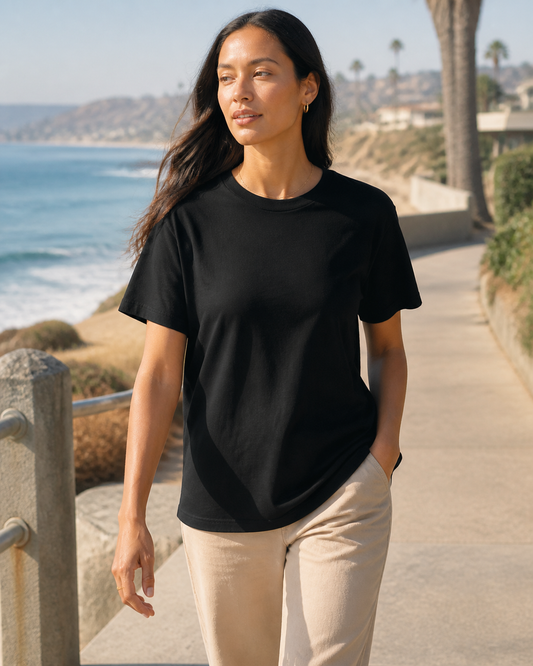 Model wearing KeAloha Black Boyfriend-Fit Tee on a coastal promenade