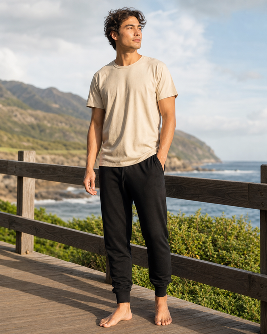 Model wearing KeAloha Black Joggers with Pockets on a coastal boardwalk