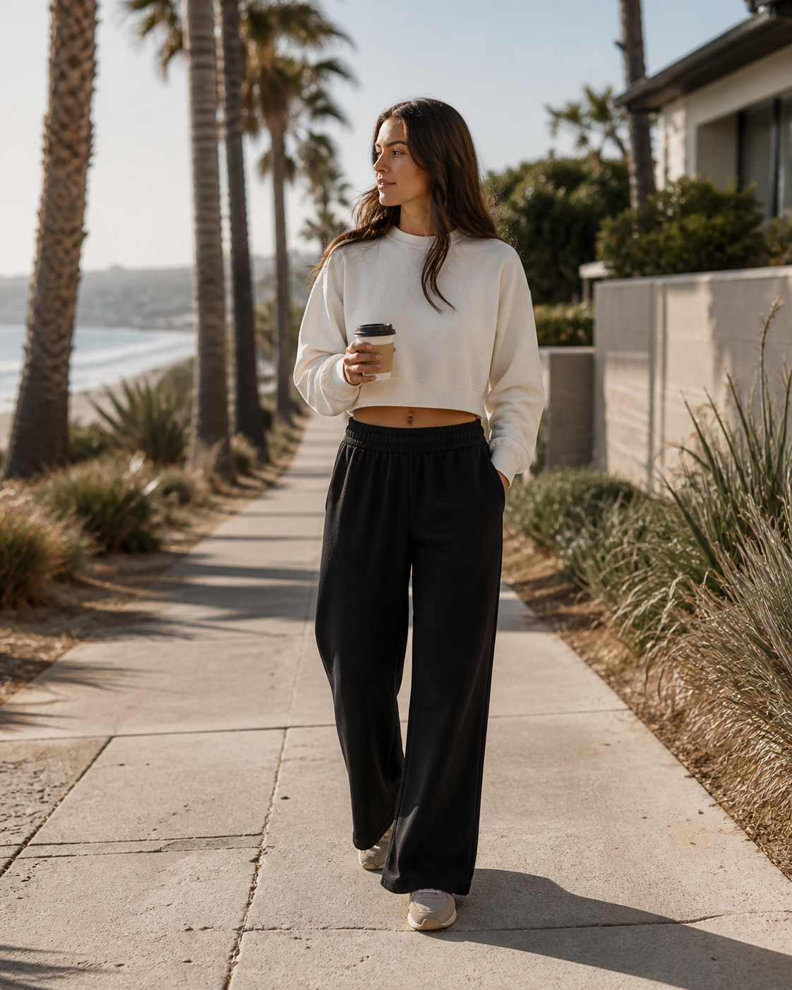 Woman wearing KeAloha Black Sweatpants on a coastal coffee walk