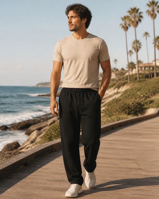 Man wearing KeAloha Black Sweatpants with Pockets on a coastal boardwalk