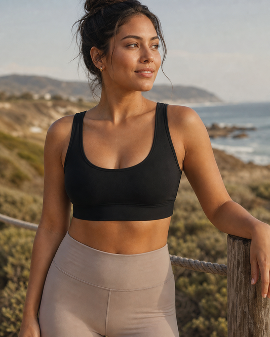 Black TENCEL Scoop Neck Sports Bra worn at a coastal overlook
