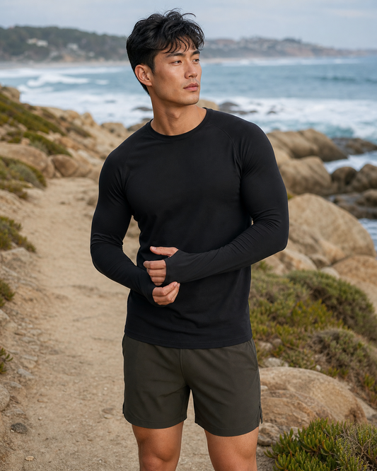 Black Thumbhole Long Sleeve Tee worn on a coastal trail