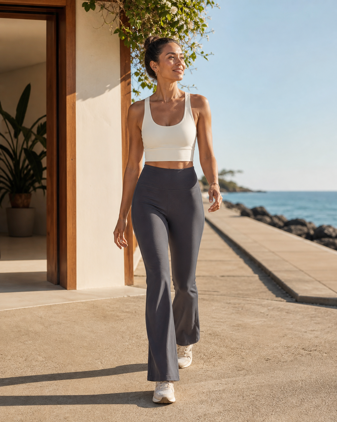 Woman wearing KeAloha Charcoal Athflow Pants on a coastal promenade