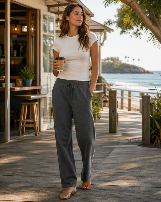 Woman wearing KeAloha Charcoal French Terry Sweatpants on a coastal boardwalk