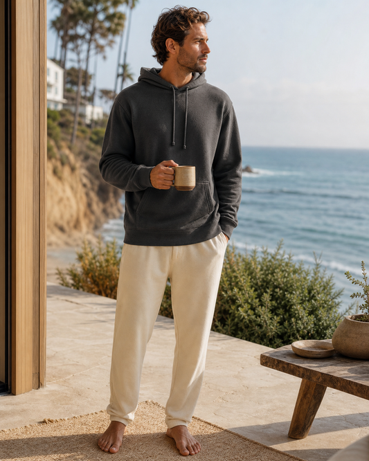Man wearing the KeAloha Charcoal Lounge Hoodie on a coastal home terrace