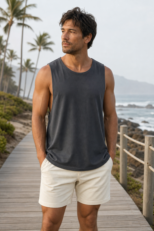 Charcoal loose-fit organic cotton muscle tank front view on a coastal boardwalk