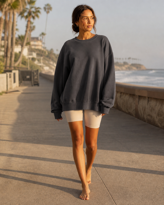 Woman wearing the KeAloha Charcoal Oversized Crewneck on a coastal promenade