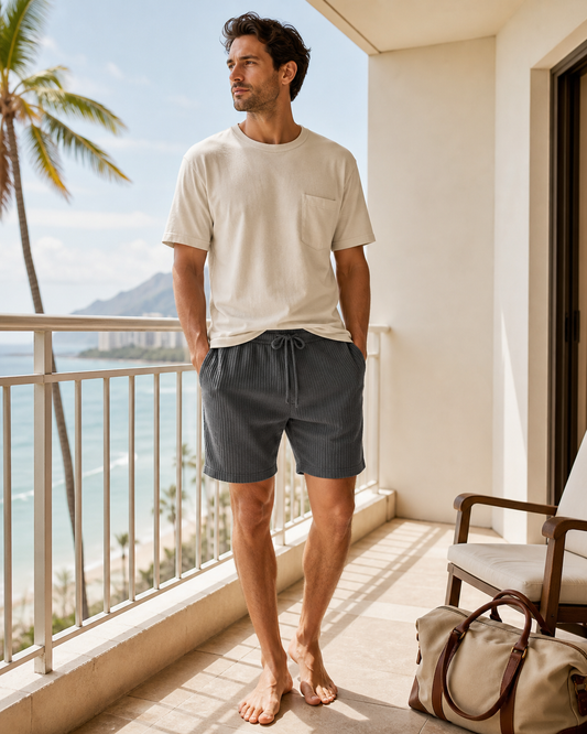 Man wearing KeAloha Charcoal Ribbed Lounge Shorts on a coastal hotel balcony