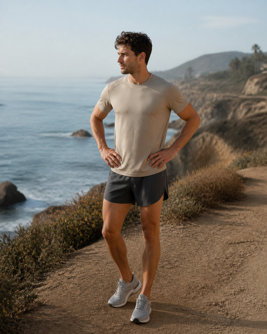 Charcoal split-hem running shorts on a coastal trail