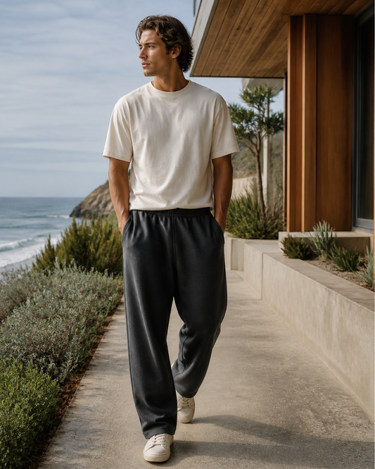 Charcoal wide-leg sweatpants beside a coastal home