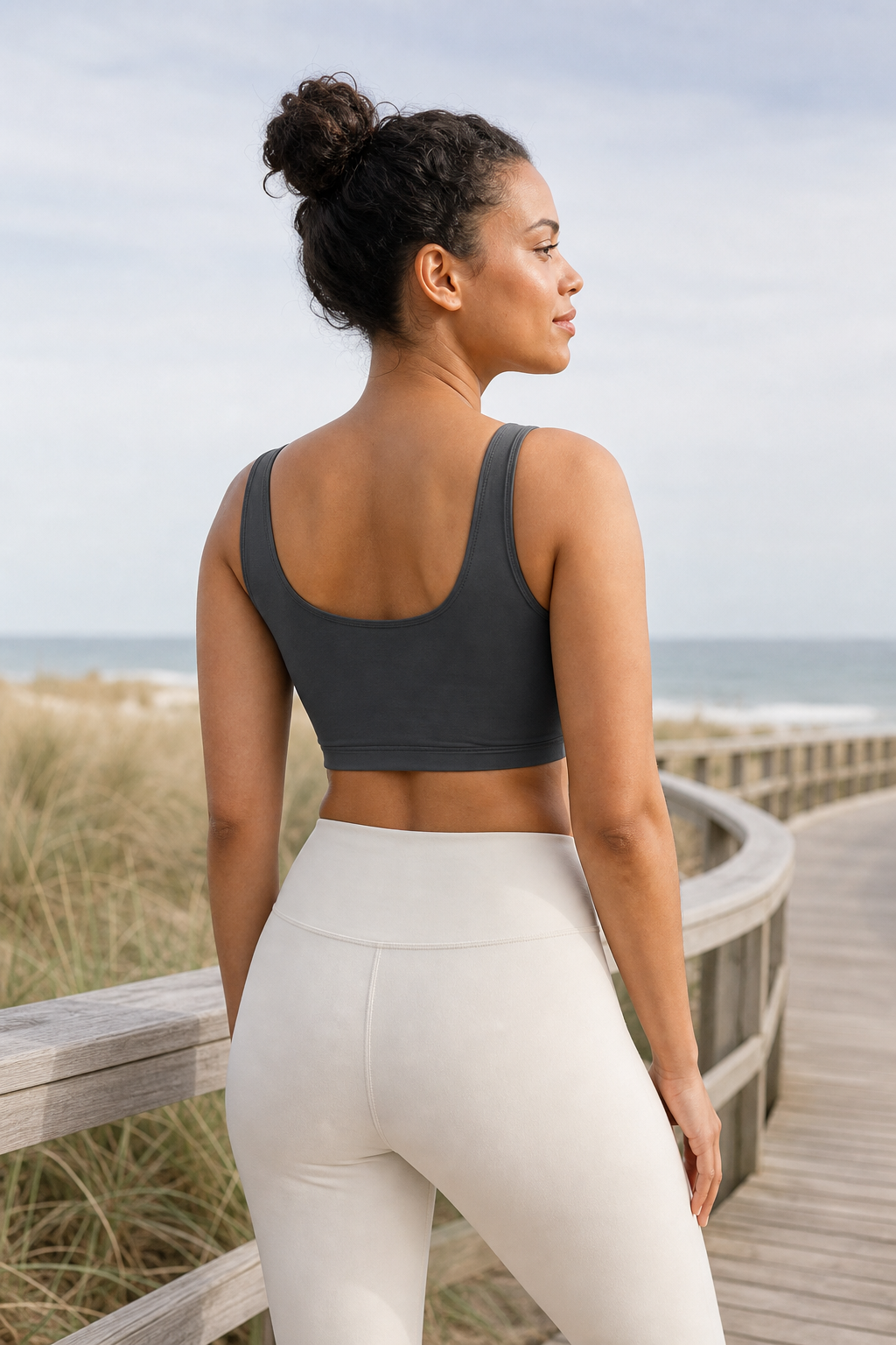 Charcoal TENCEL Scoop Neck Sports Bra shown from the back on a beach boardwalk