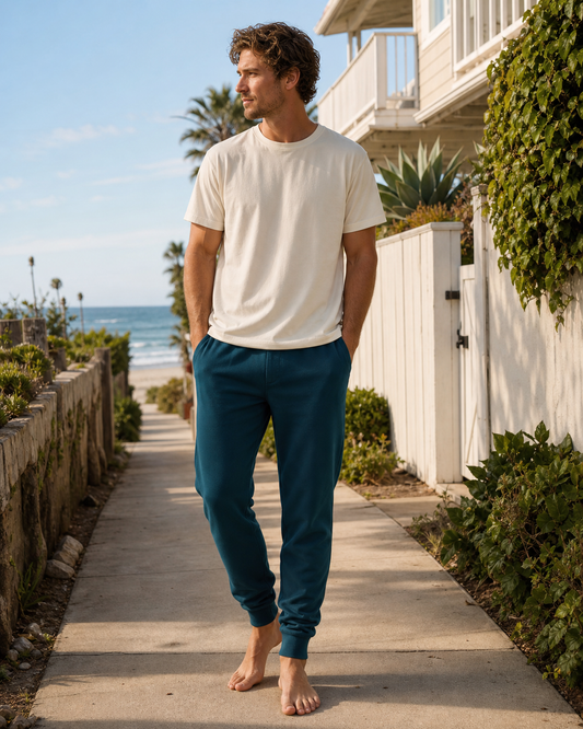 Deep teal tapered organic cotton joggers in a coastal neighborhood