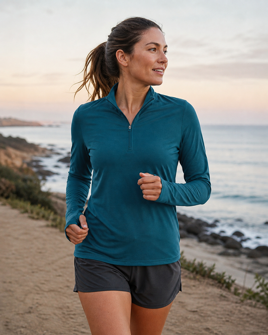 Deep teal lightweight TENCEL quarter-zip on a coastal running path