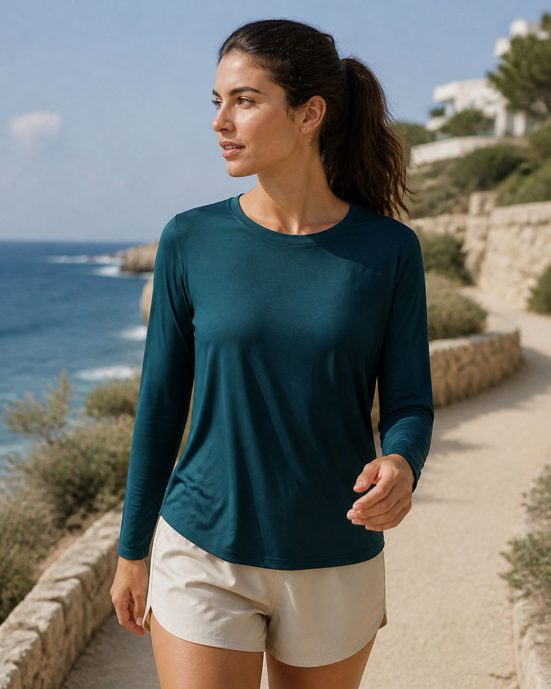 Woman wearing a lightweight deep teal TENCEL long sleeve tee on a coastal walk