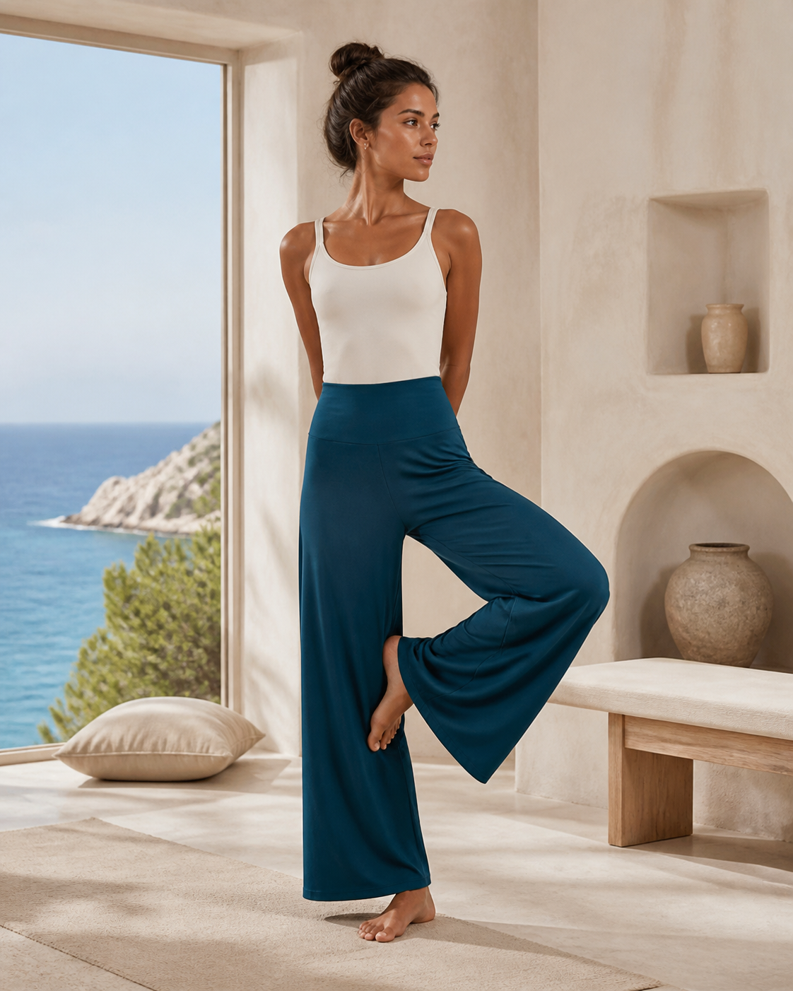Woman wearing deep teal wide-leg TENCEL yoga pants in a coastal studio