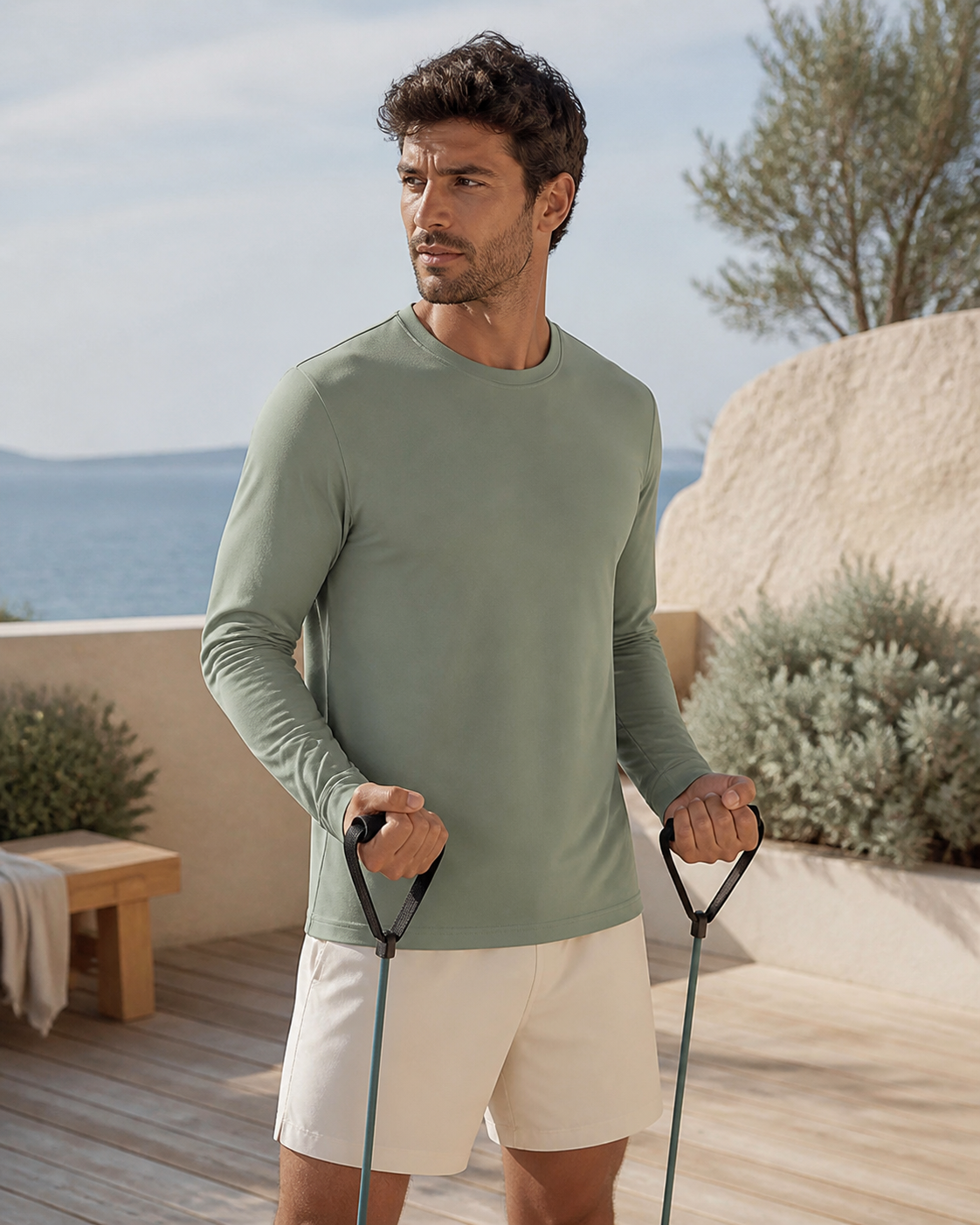 Man training in a sage organic cotton long sleeve tee on a coastal deck