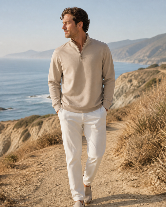 Man wearing a sand half-zip pullover on a breezy coastal bluff trail